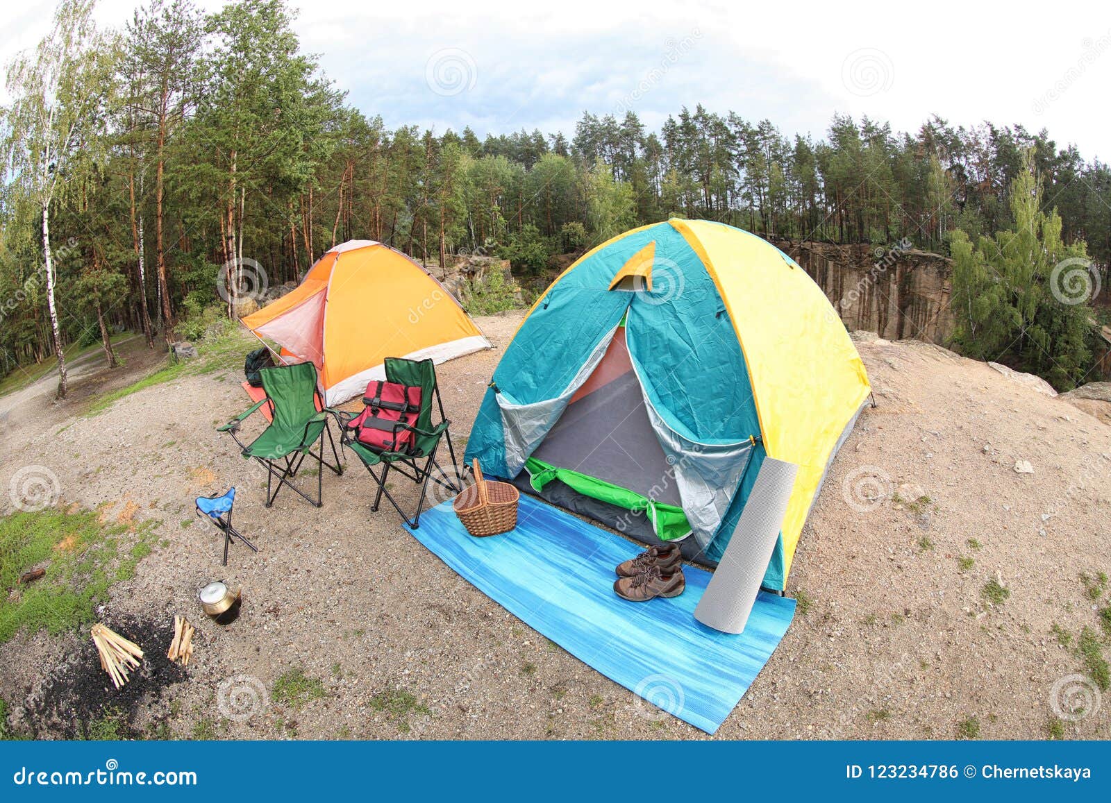 Camping Tents and Accessories in Wilderness on Summer Day Stock Photo