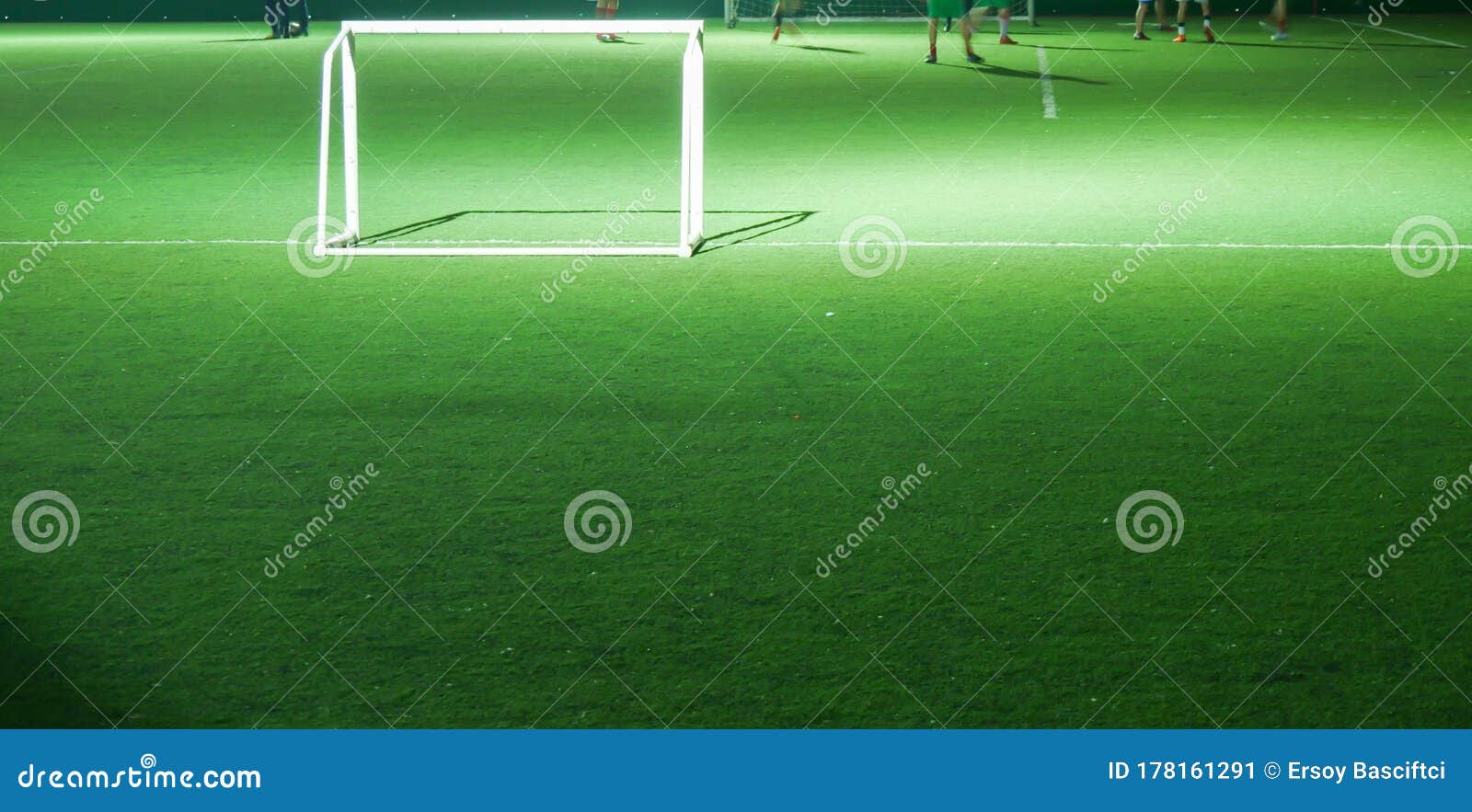 Cena de futebol durante jogo noturno com close-up de dois