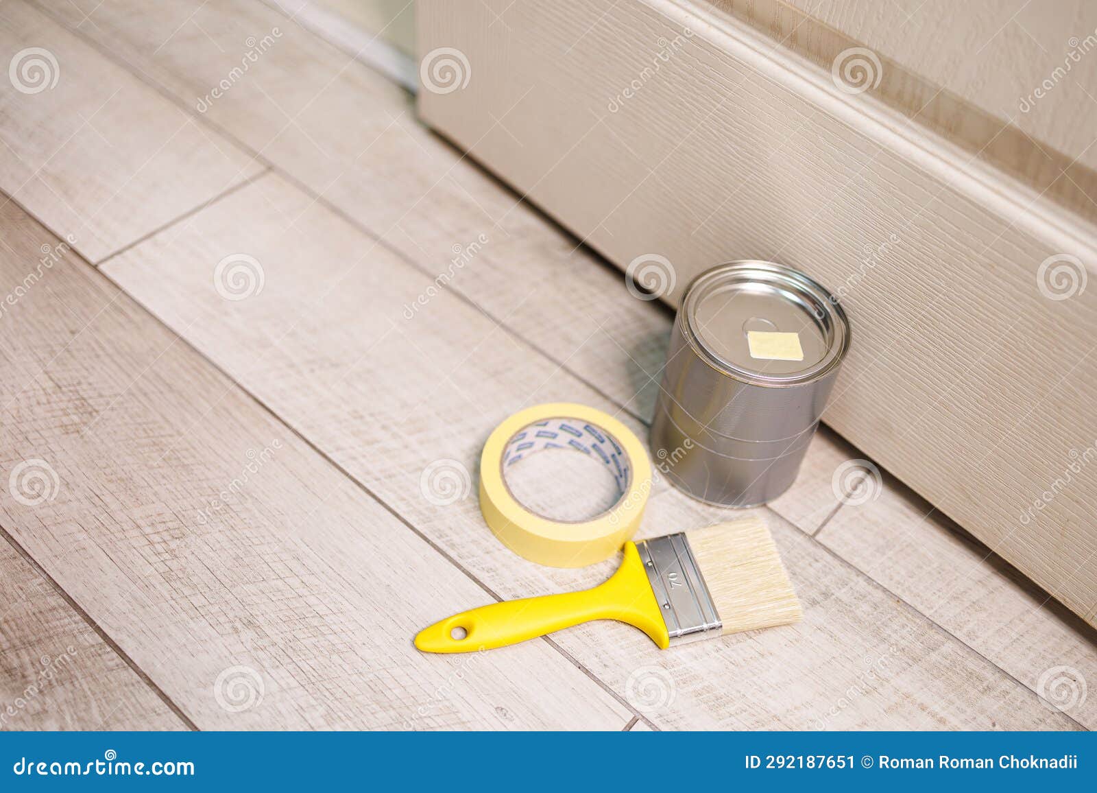 A Can of Paint and a Paintbrush are on the Floor. Repair Staining the