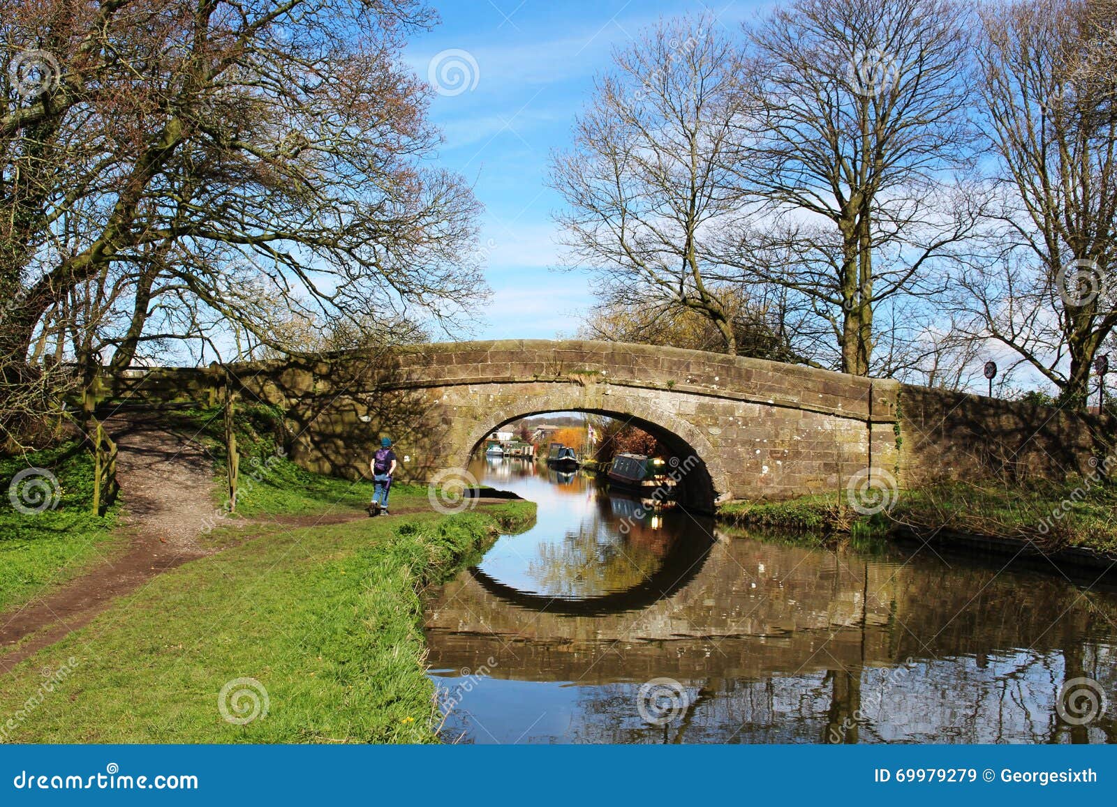canal bridge and reflection with walker on towpath