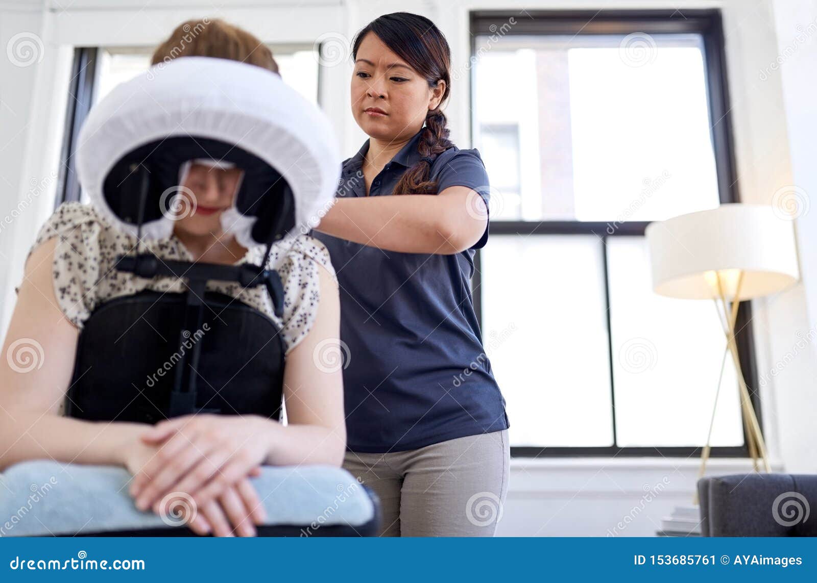 Chinese Woman Massage Therapist Giving A Neck And Back Pressure