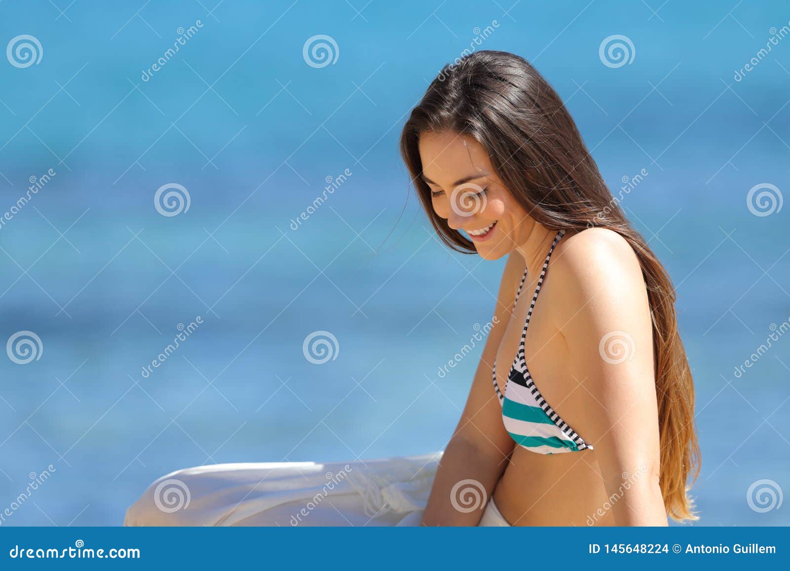 Candid Woman in Bikini Sitting on the Beach Stock Photo pic