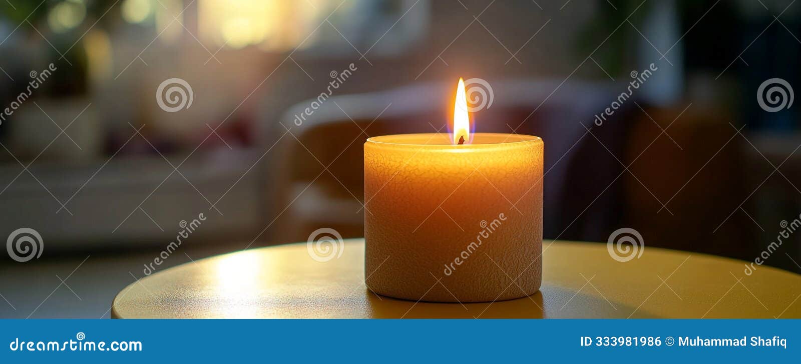 a candle burning on a round yellow table, the bright color intensifying the warm light