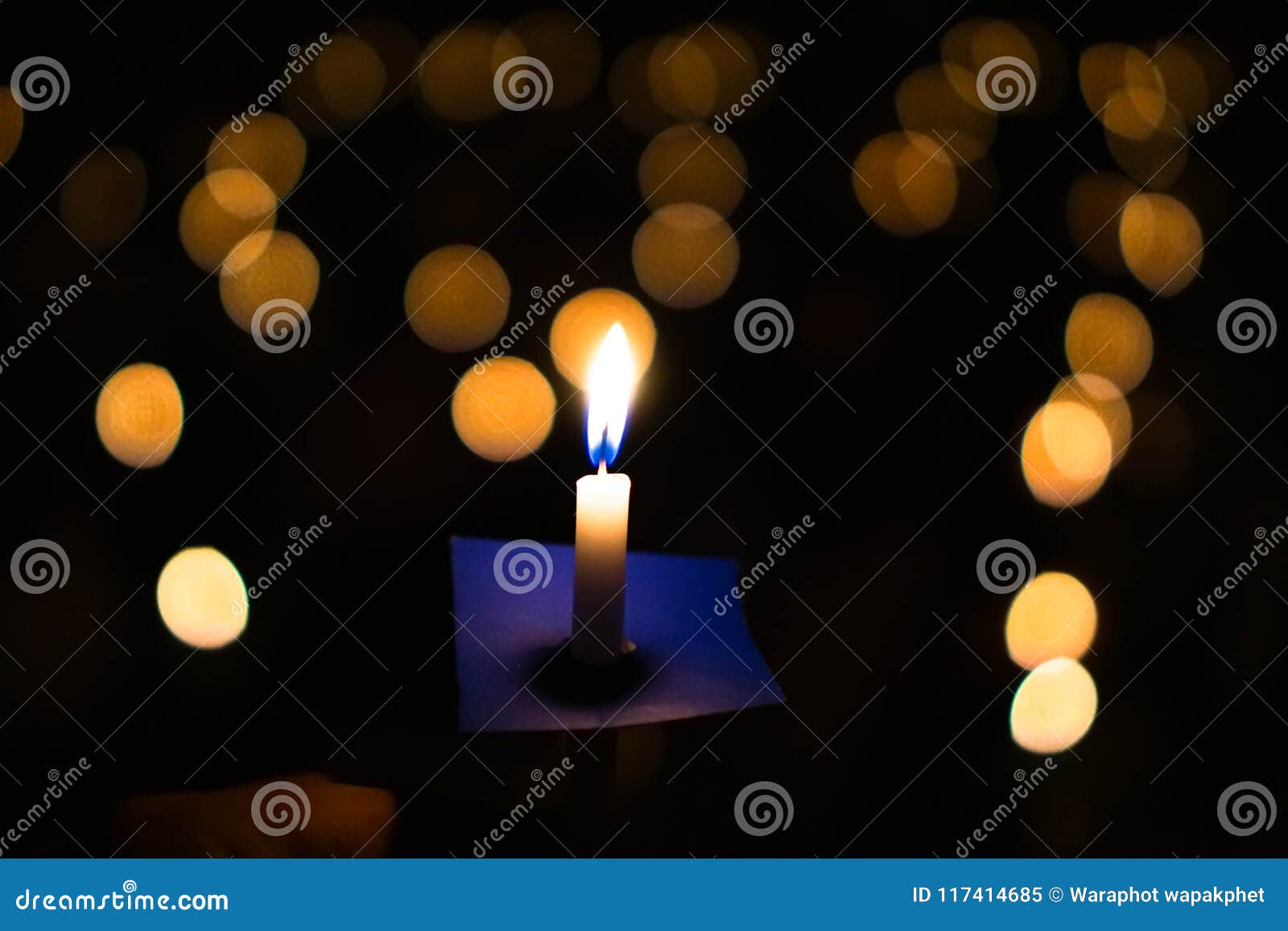 candle flame at night with bokeh on dark background with go light blessed is the light of holiness and miracles.