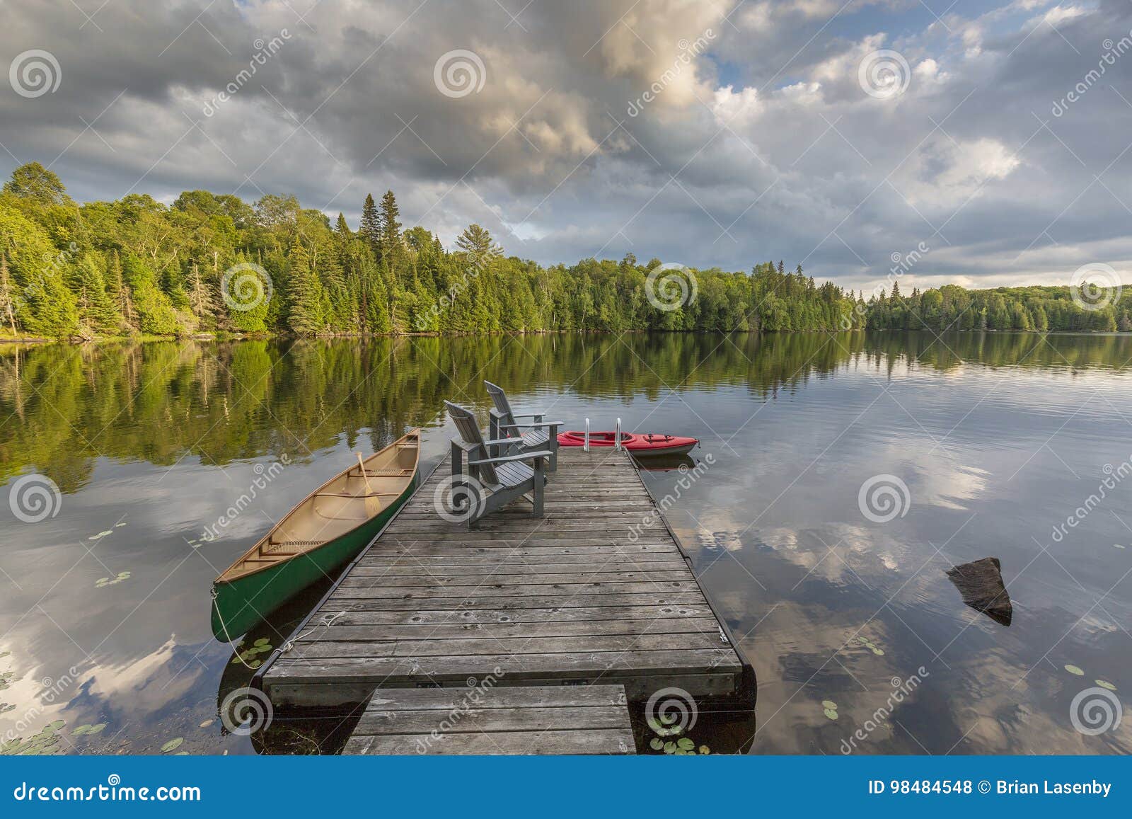 canoe and kayak tied to a dock on a lake in ontario canada