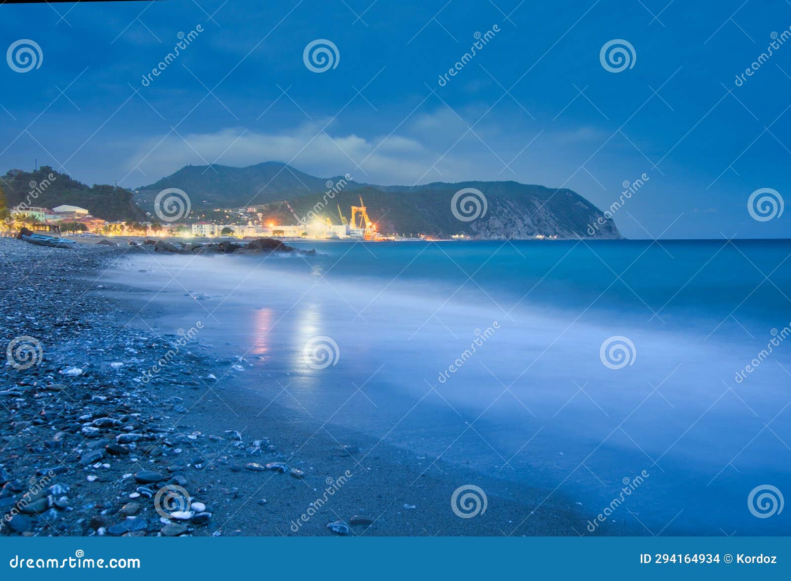 sea shore and large metal cranes in riva trigoso shipyard during summer night