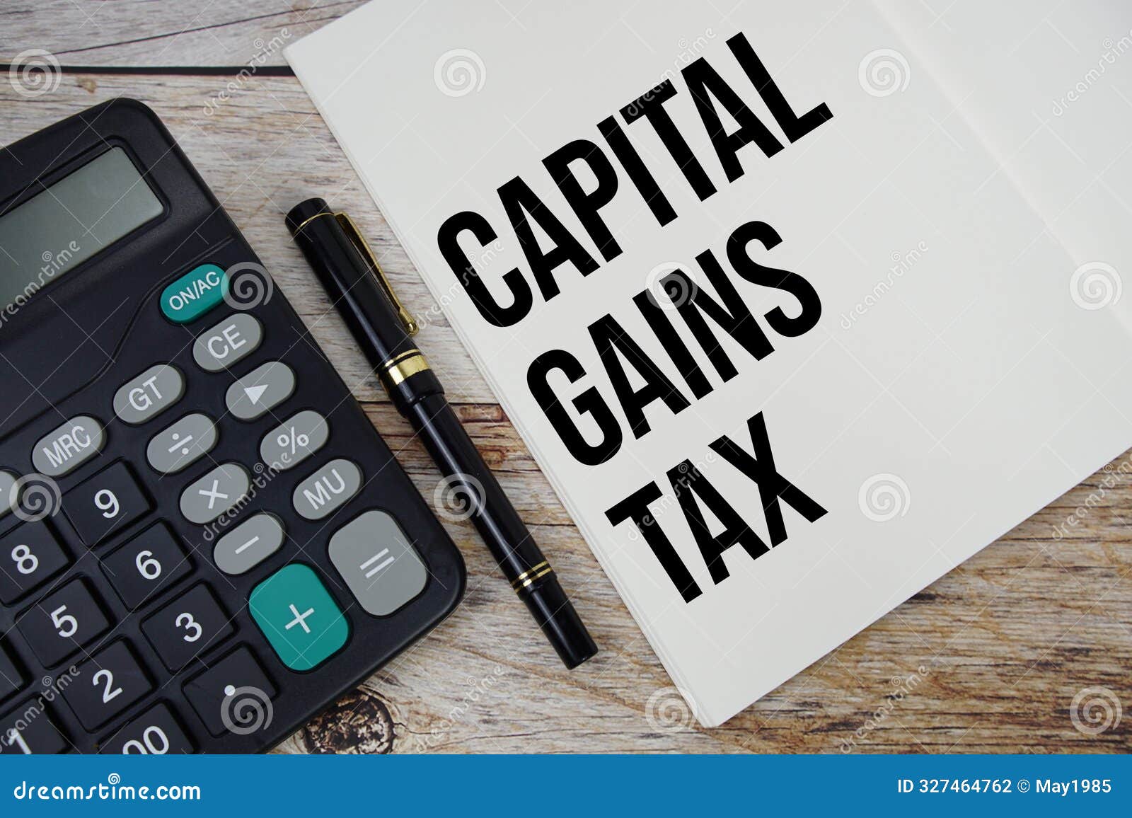 capital gains tax text message written on note page with calculator top view on wooden background