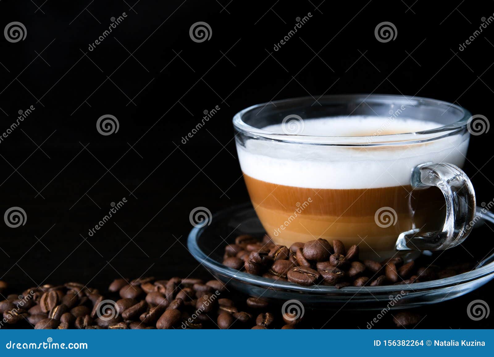 Capuccino con granos de café alrededor en taza transparente Stock Photo