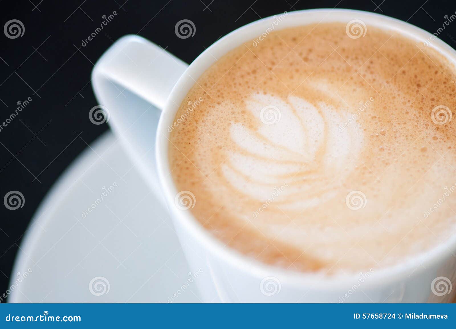 cappuchino or latte coffe in a white cup on a dark background