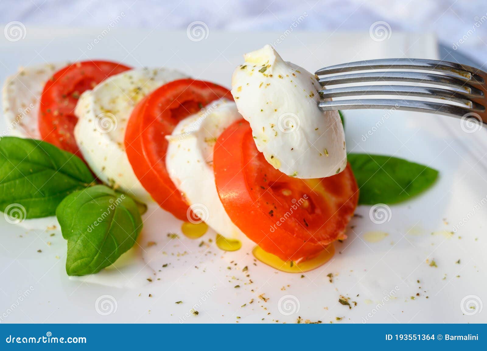 caprese salad made with fresh soft white italian cheese mozzarella buffalo, green basil, red tomatoes and origano herb