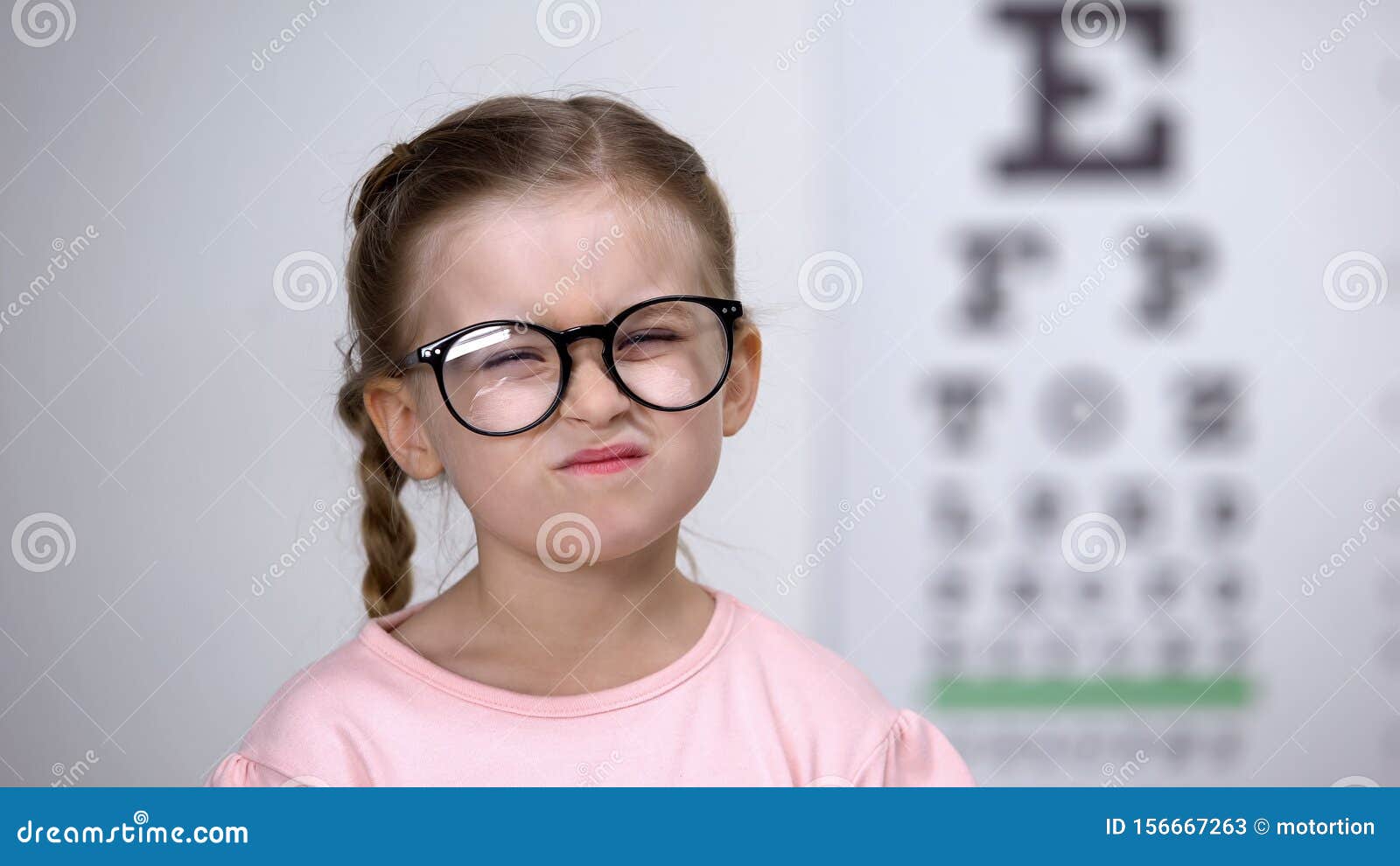 capricious little girl afraid of eyeglasses, feeling insecure, vision correction