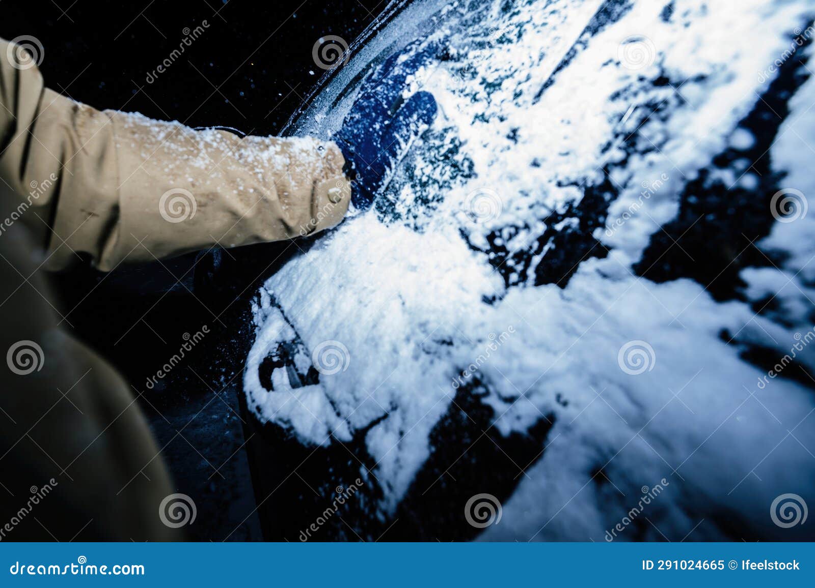 early morning snow removal from frozen car after tempest