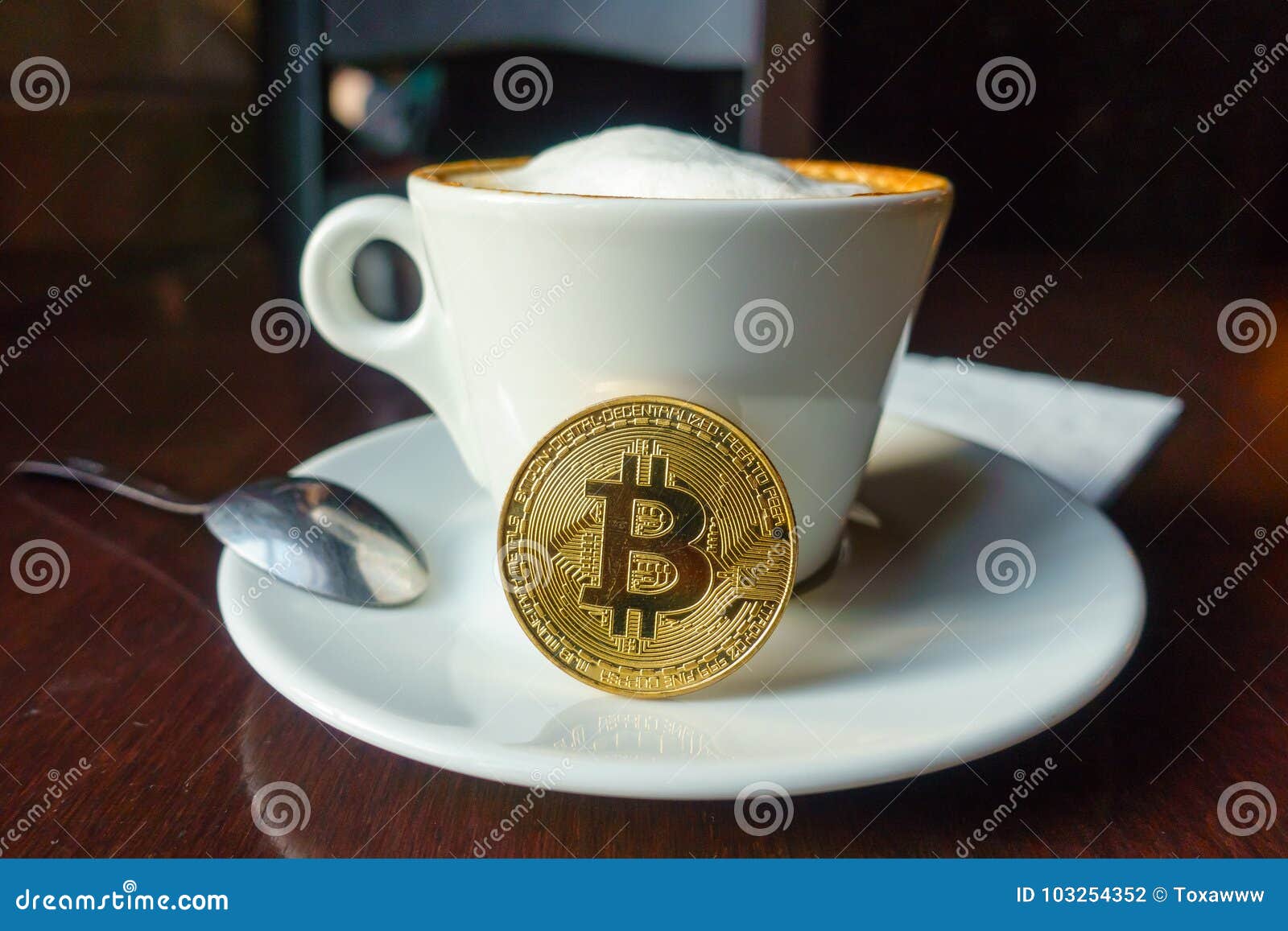 capuccino and bitcoin gold coin on the table in cafe