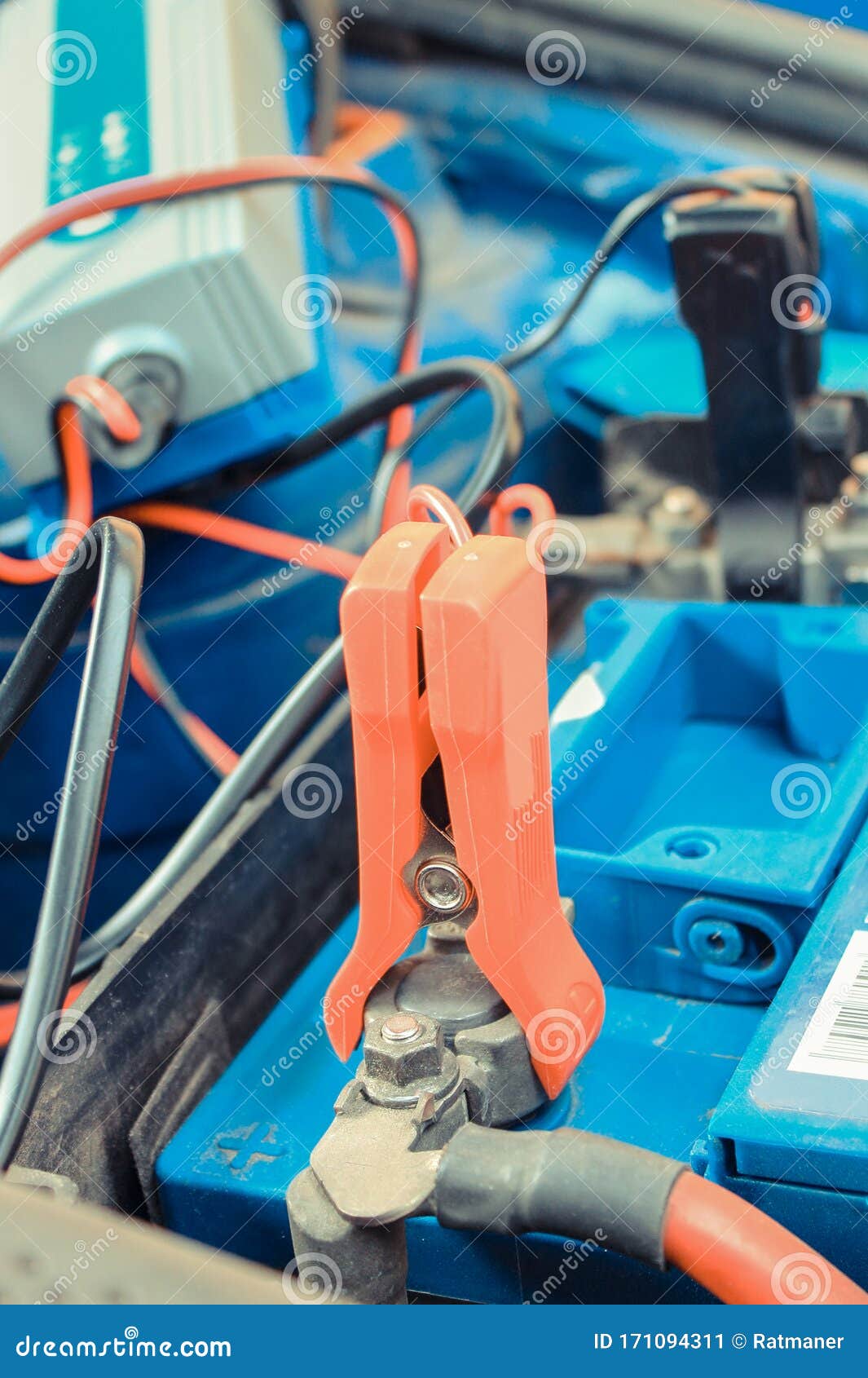 Car Battery Charging Under Hood of Car. Charger with Connected Cables