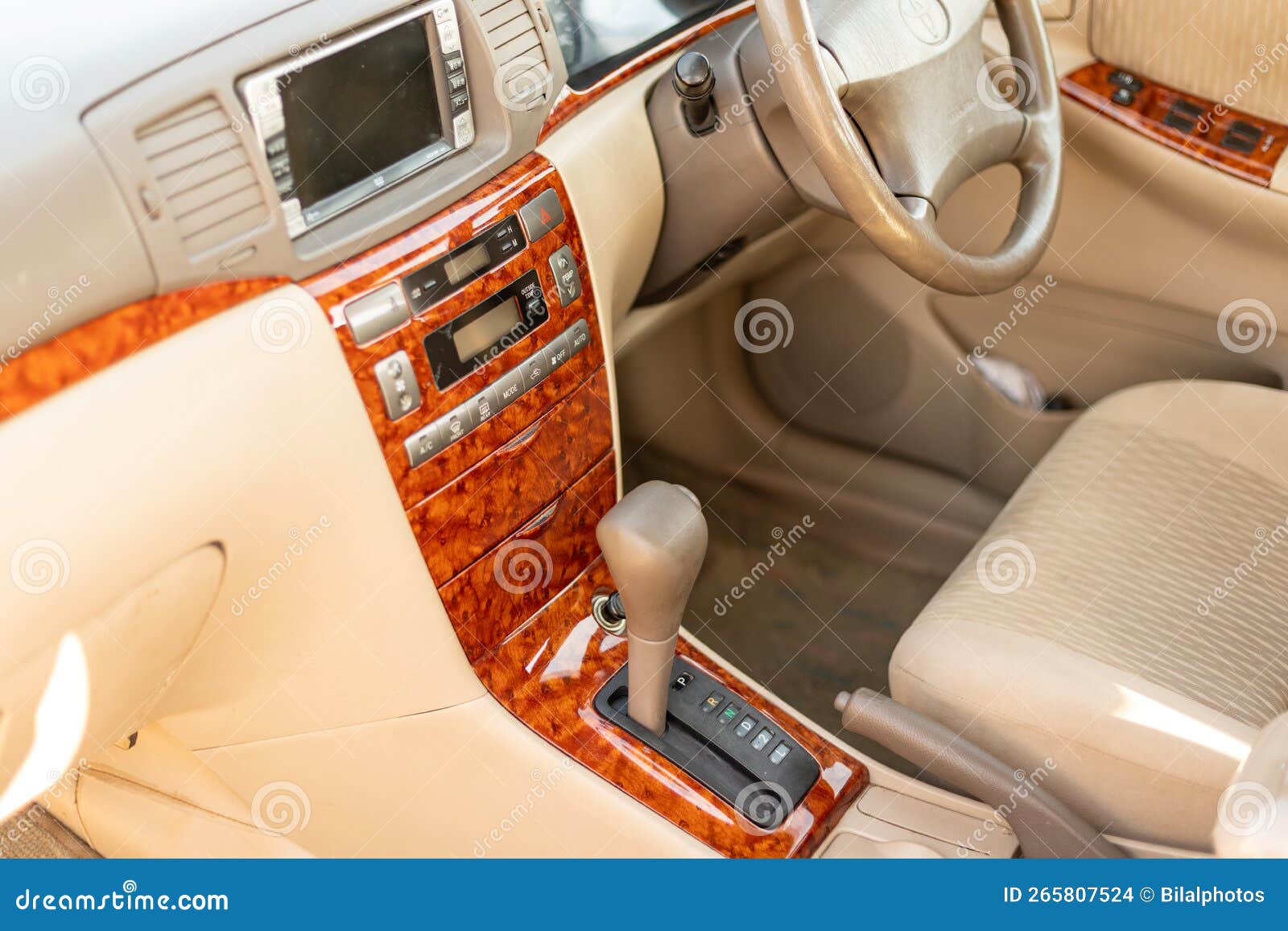 Car Dashboard with Wood Trim and Beige Interior Closeup Stock Photo