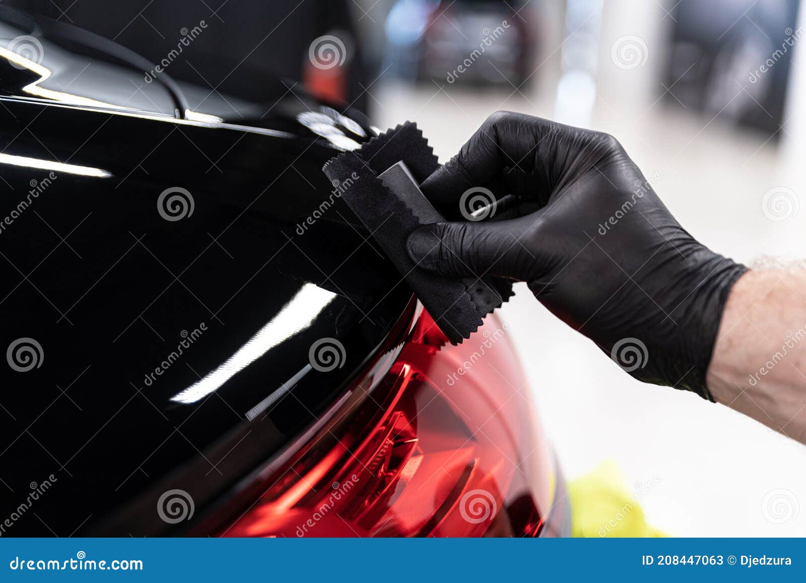 car detailing studio worker applying ceramic coating