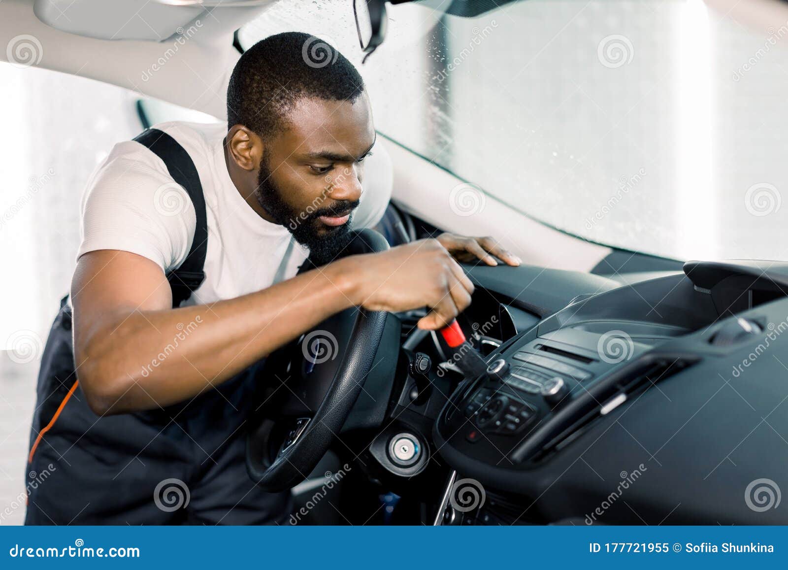 Car Detailing and Car Wash Concept. Young Black Man, Car Wash Worker, Cleaning Gaps in the