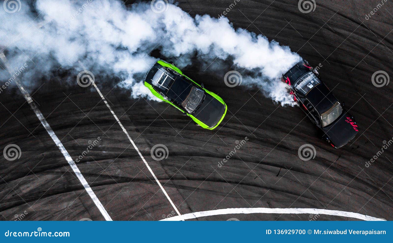 car drift battle, two car drifting battle on race track with smoke, aerial view