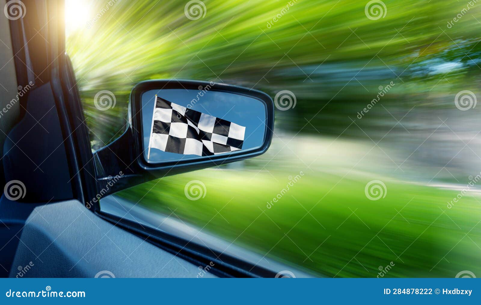 Car Driving with Checkered Race Flag in Rear View Mirror Stock Photo