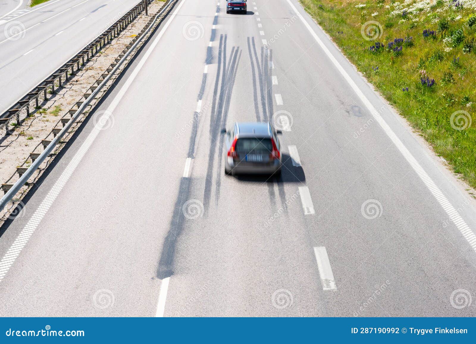 Car Driving Fast Down a Highway with Log Tire Skid Marks.. Stock Photo