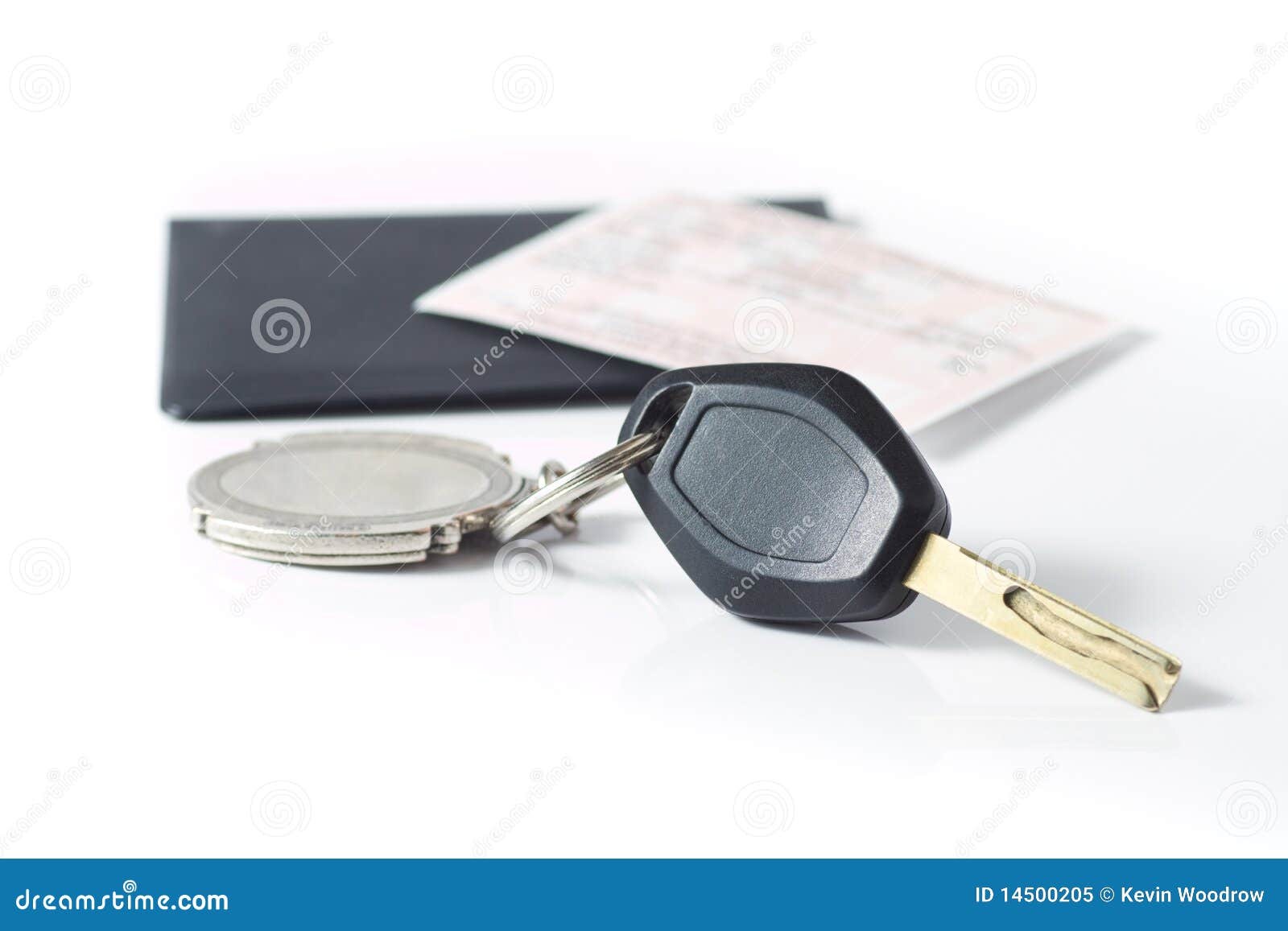 car keys with insurance paper behind on white