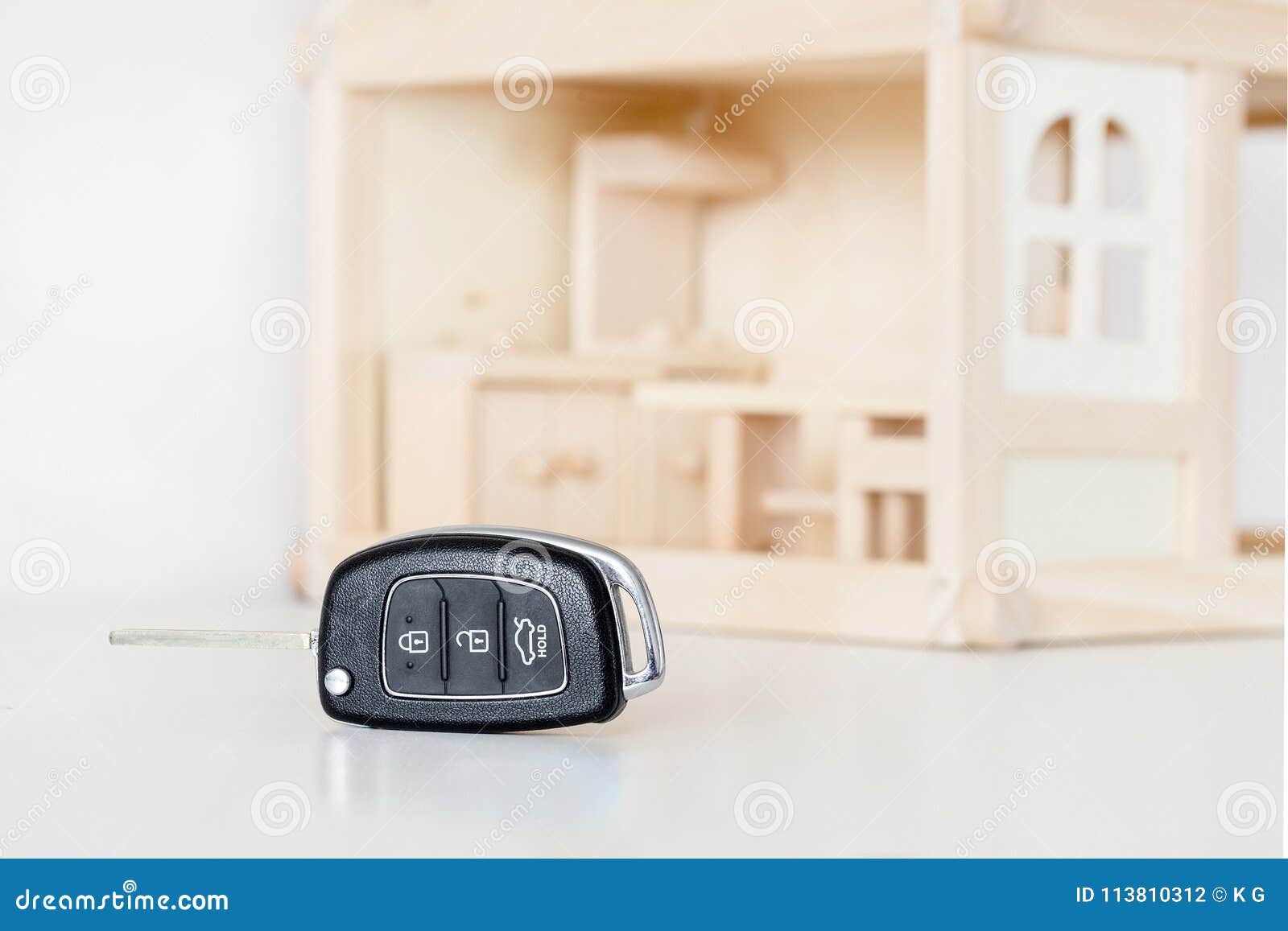 car keys with wooden house model on background. choice of byuing basic need. decision of priority or primary necessity