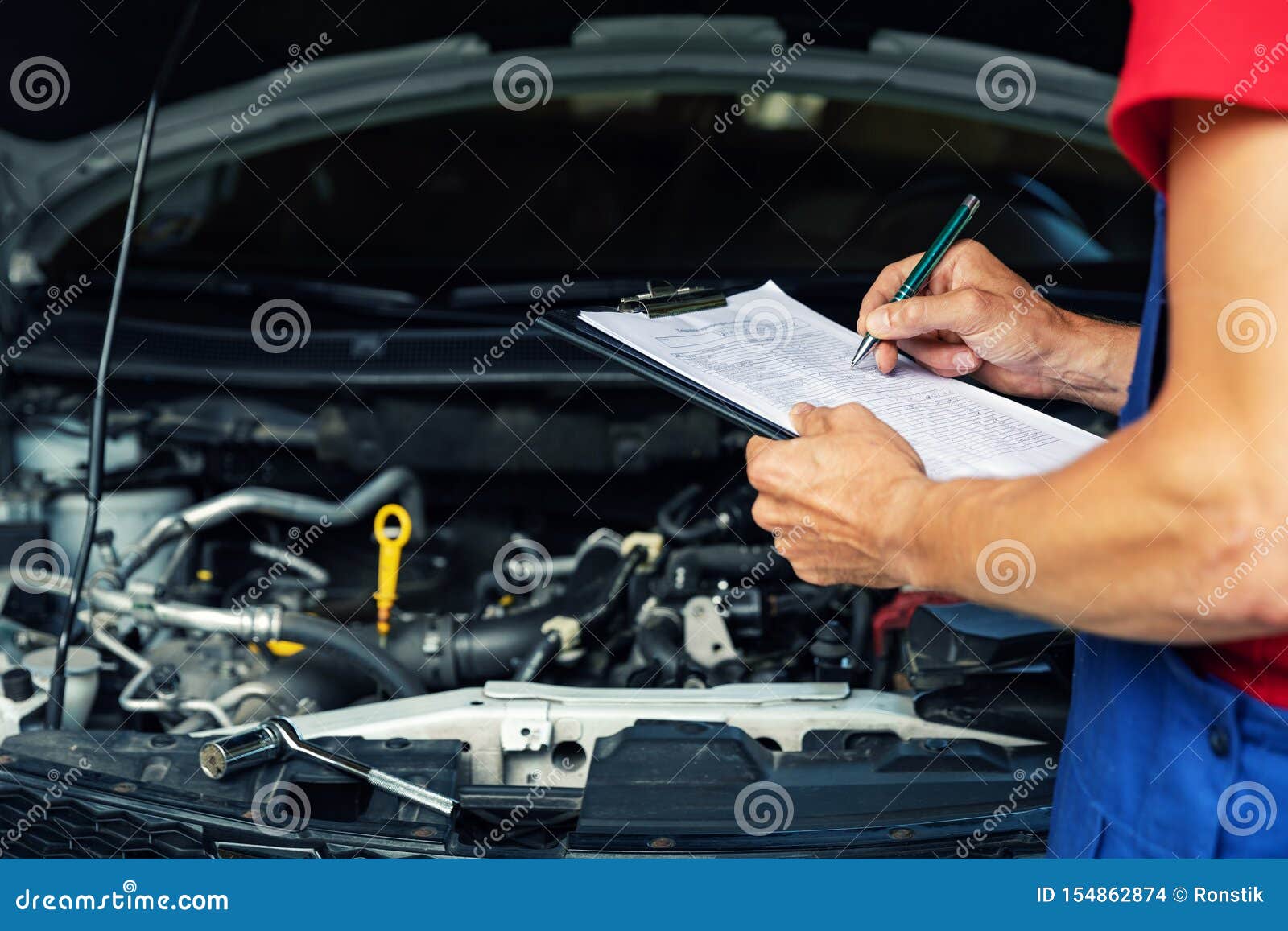 car maintenance and repair - mechanic writing checklist paper on clipboard