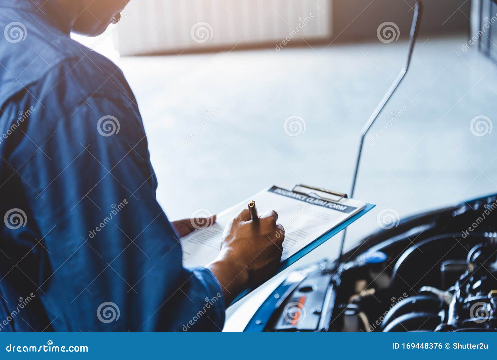 Car Mechanic Holding Clipboard And Checking To Maintenance Vehicle By