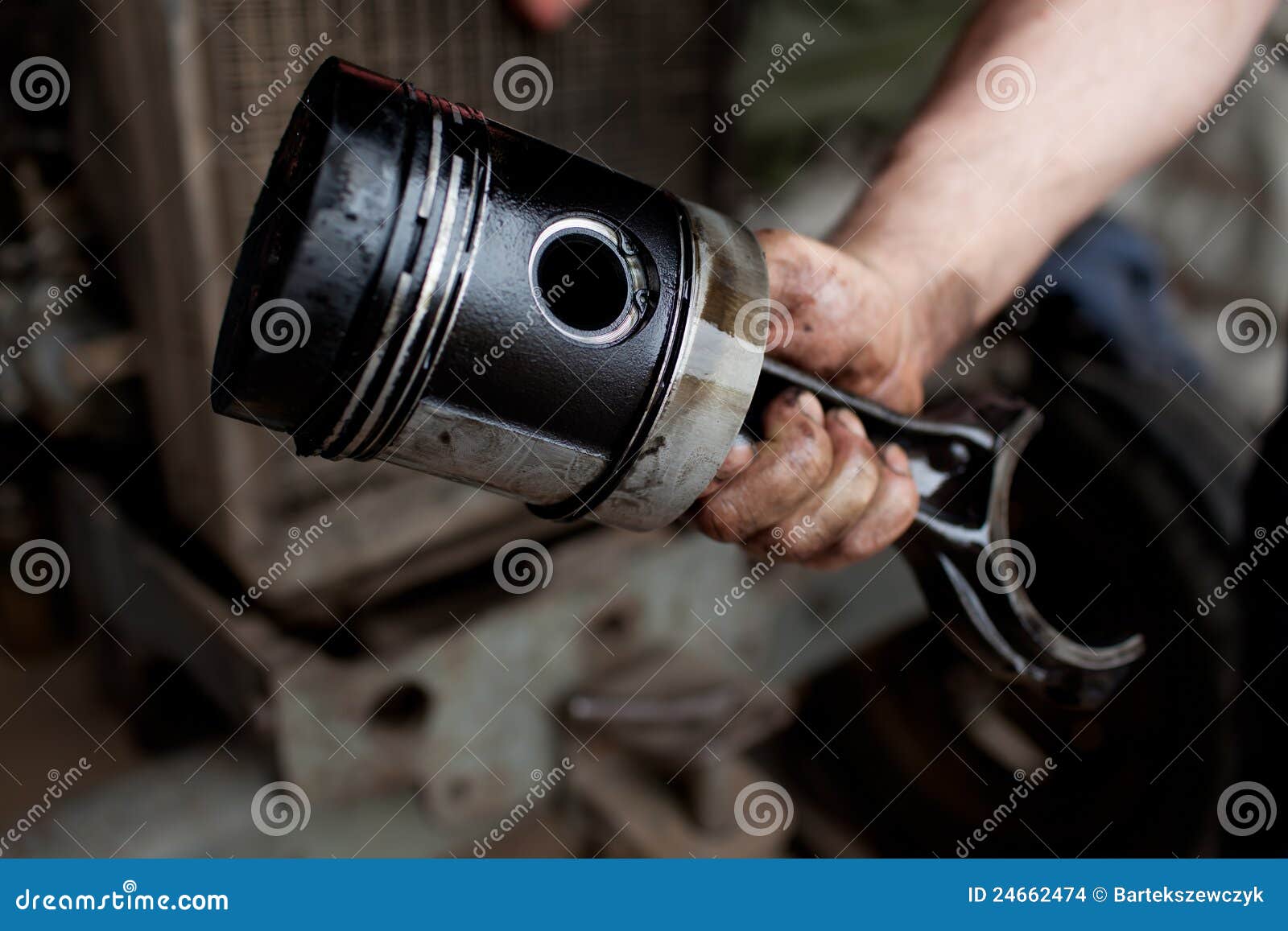 car mechanic holding piston