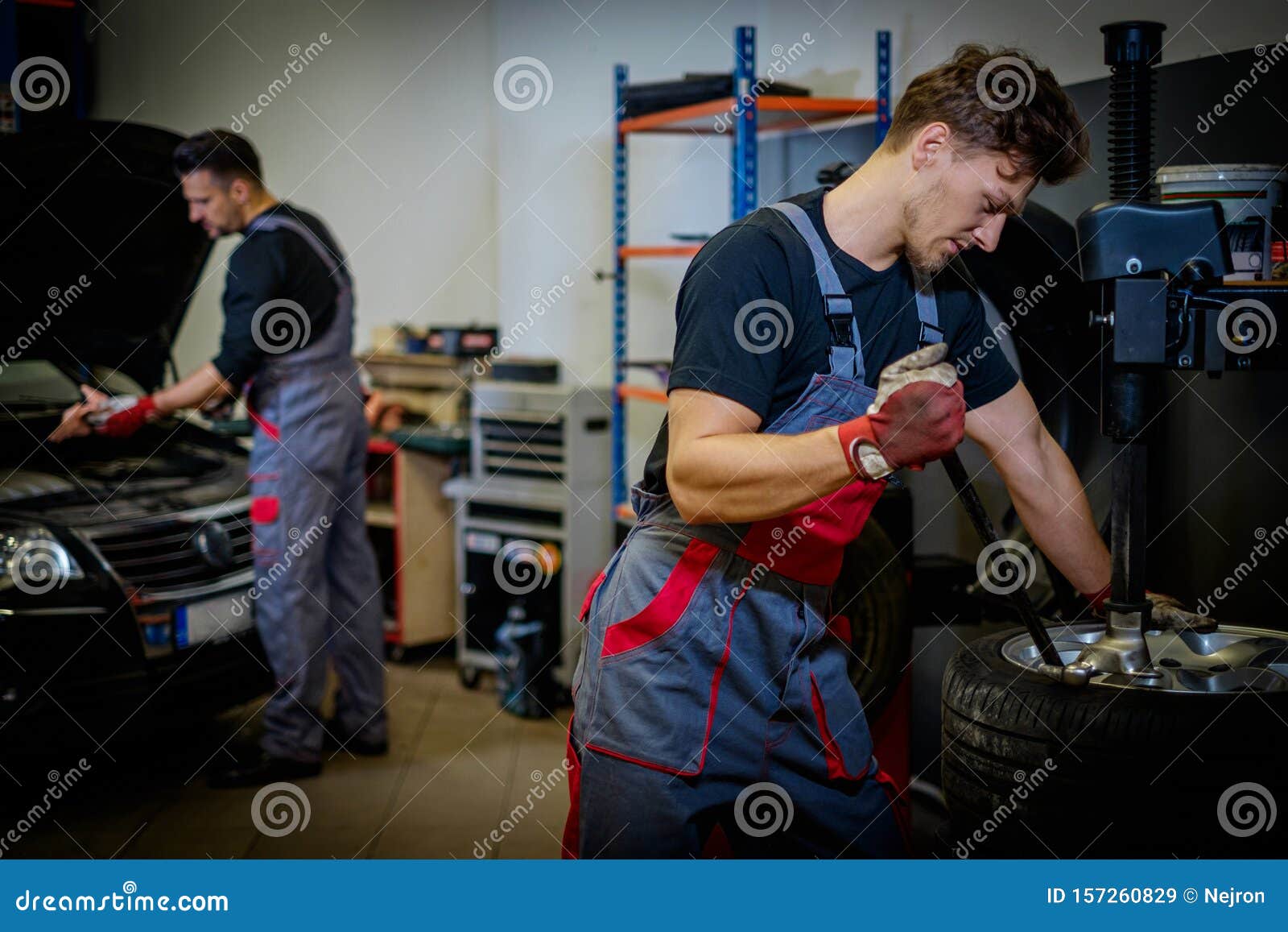 Car Mechanic Mounts Tire On Wheel In A Stock Image Image of