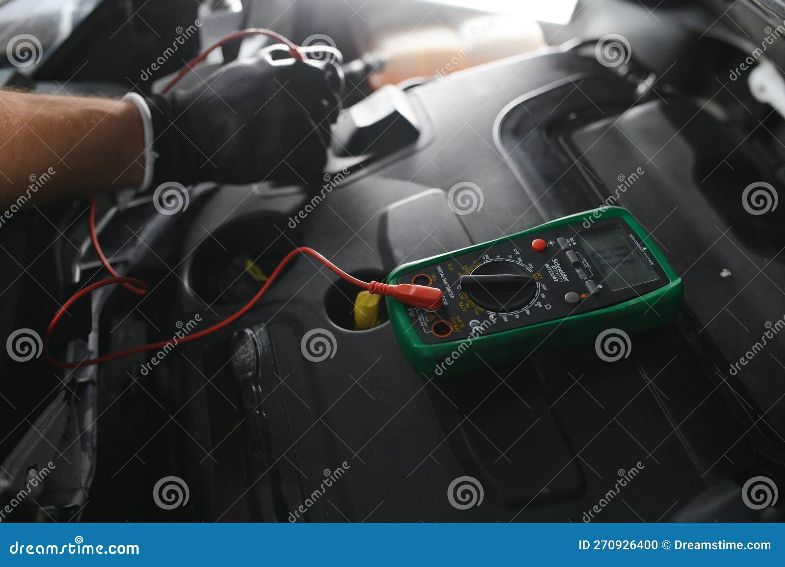 Car Mechanic is Using a Multimeter with Voltage Range Measurement To