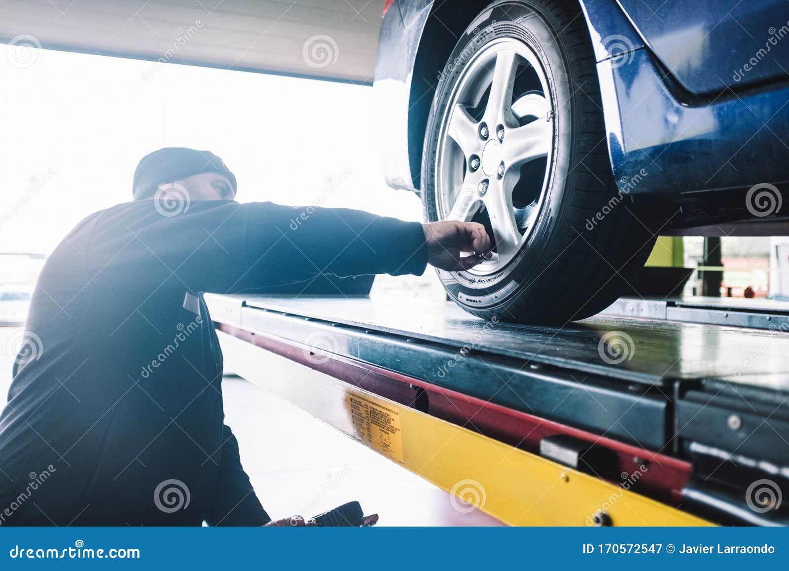 caucasian mechanic checking the wheels presion during a tune-up