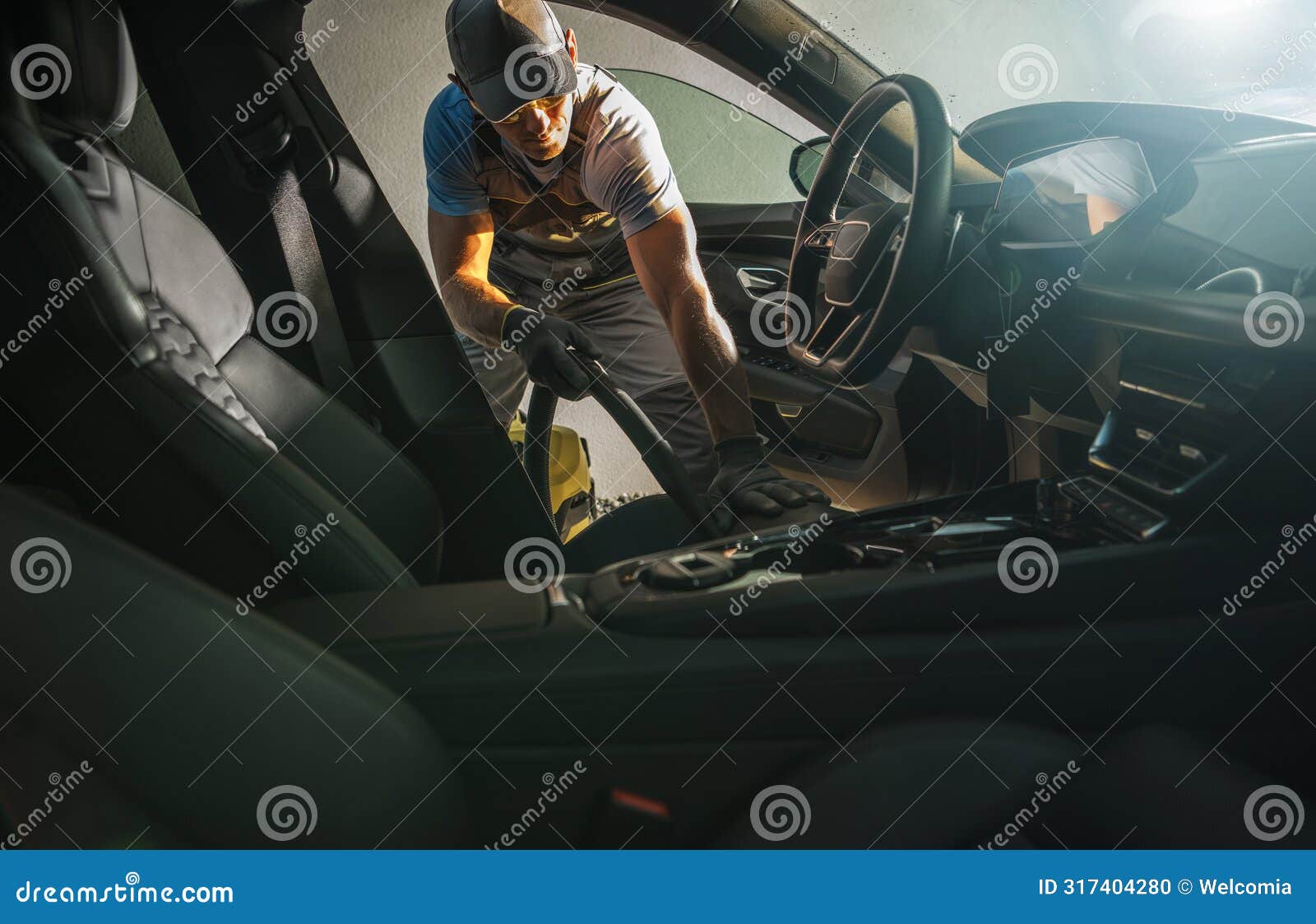 car owner vacuuming his vehicle interior