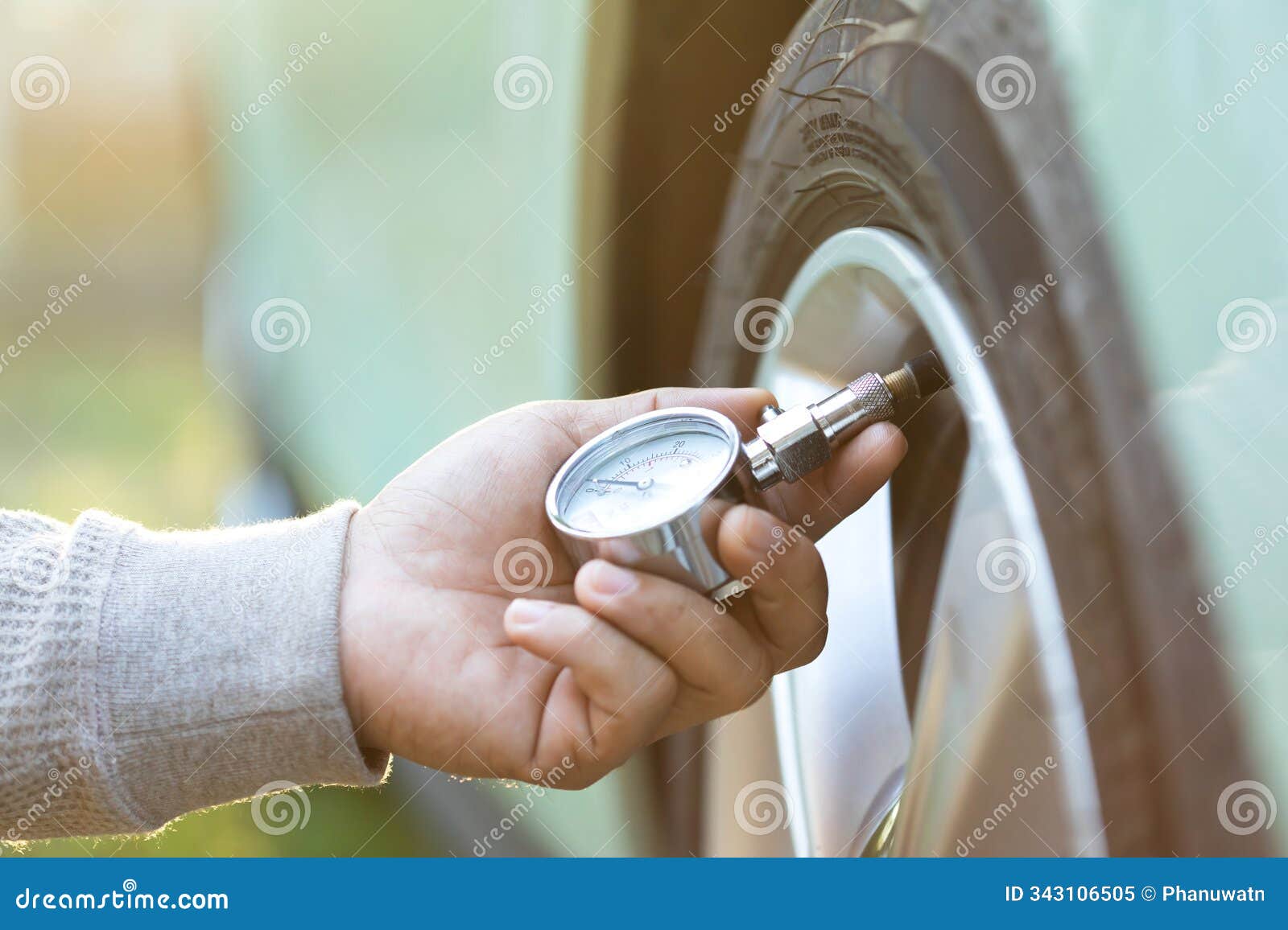 car owner uses a pressure gauge to check tire inflation, emphasizing vehicle readiness and the importance of proper tire