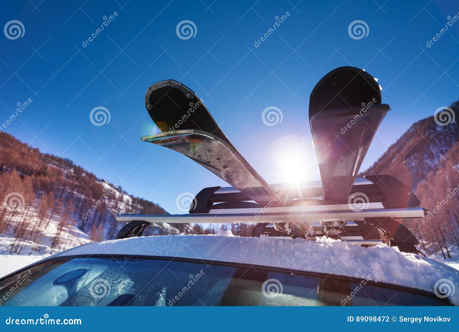 car roof with two pairs of skis on the rack