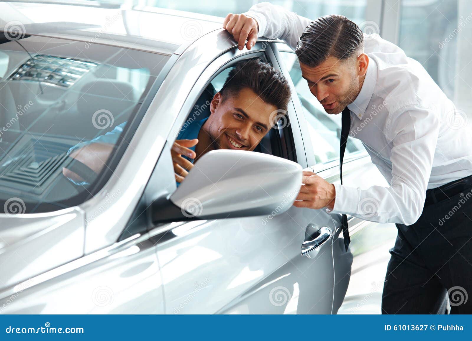 car sales consultant showing a new car to a potential buyer in s