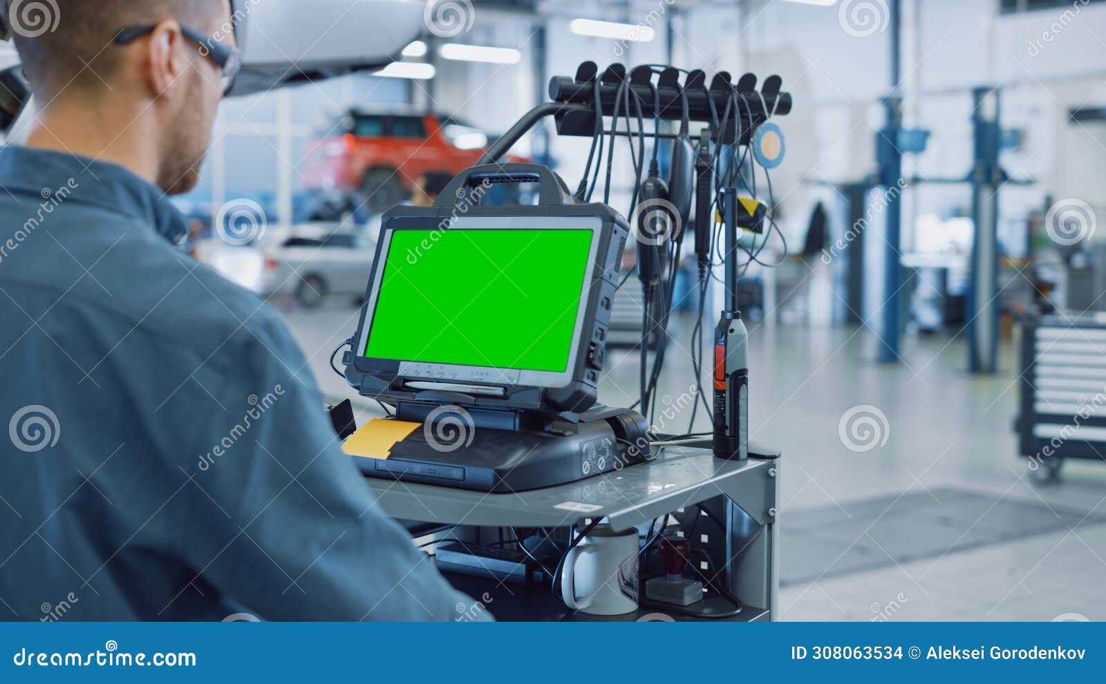 Car Service Mechanic is Running a Diagnostics Software on an Advanced