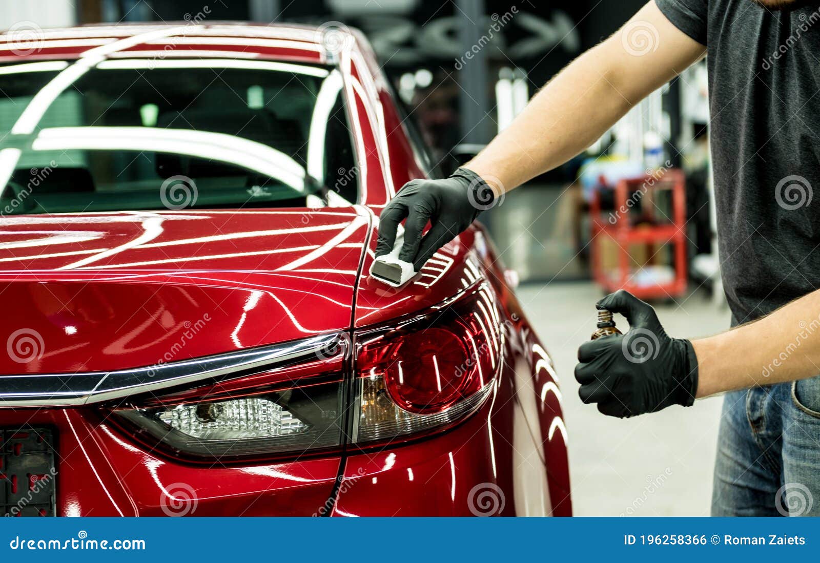 car service worker applying nano coating on a car detail.