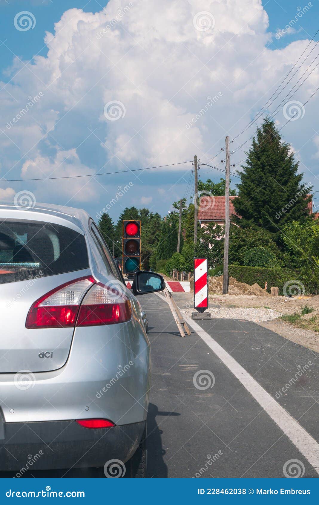 The Car is Stopped in Front of the Road Construction Traffic Light