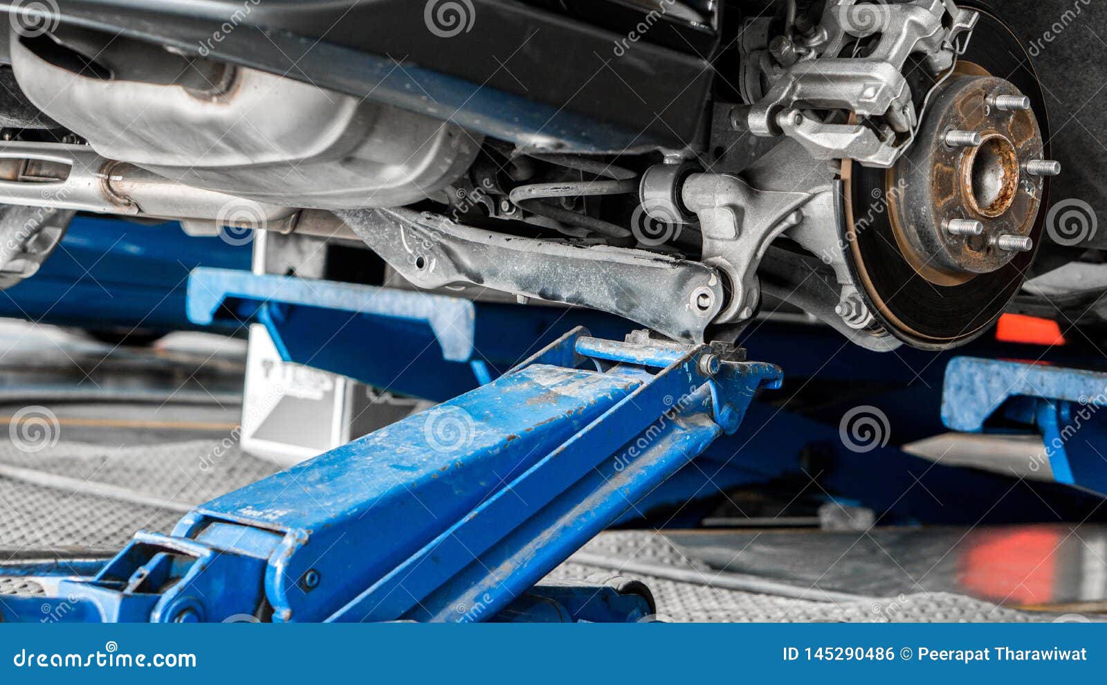 Car Suspension Service With Hydraulic Floor Jack In Maintenance