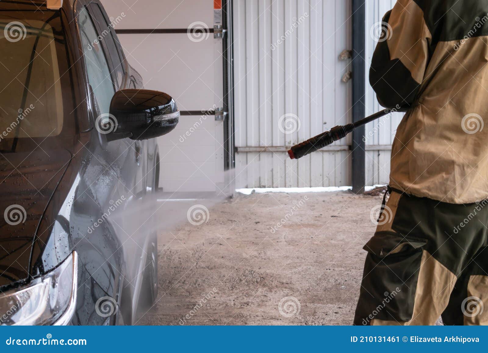 car wash with karcher. the man washes the black car