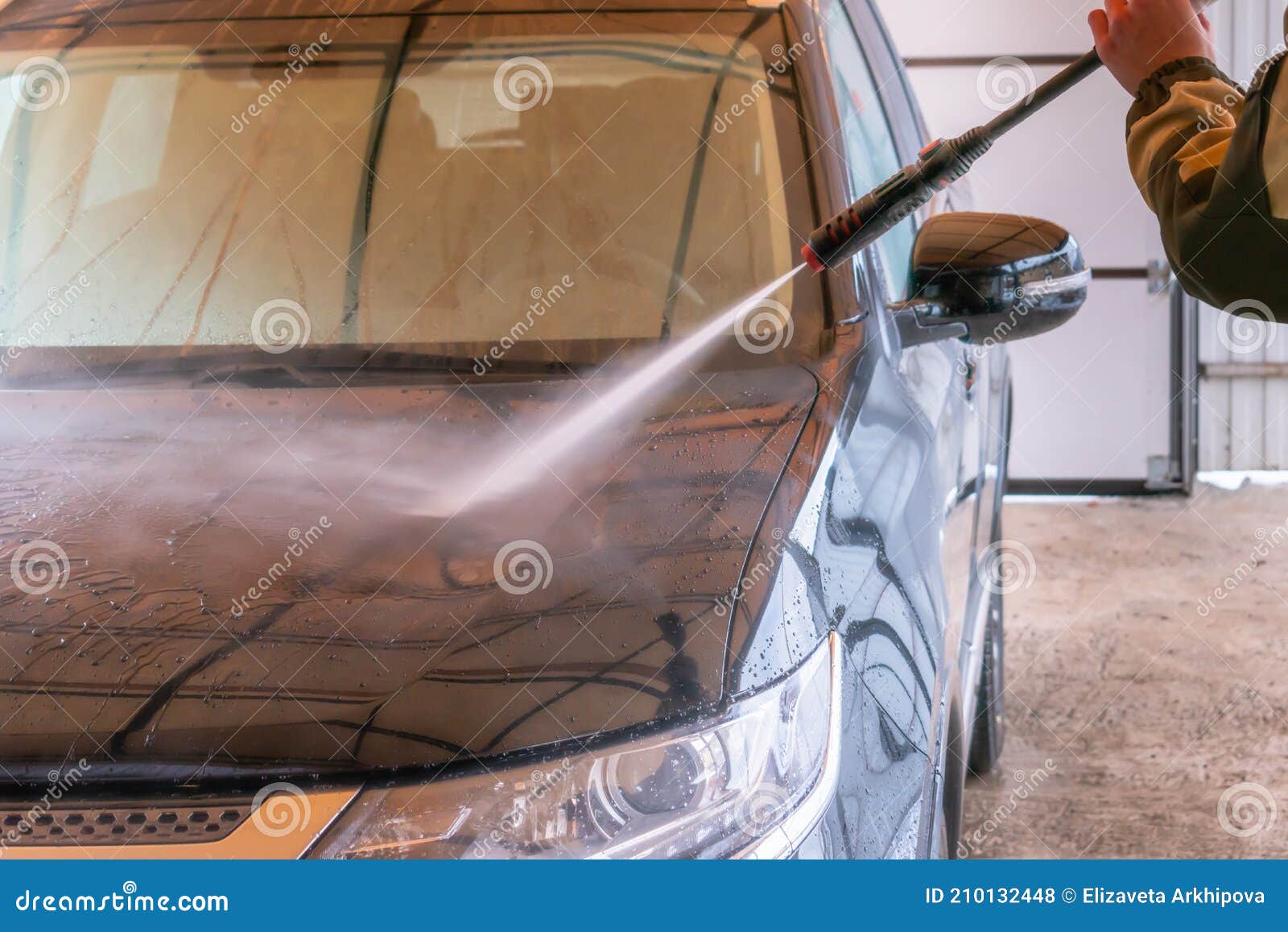 car wash with karcher. the man washes the black car