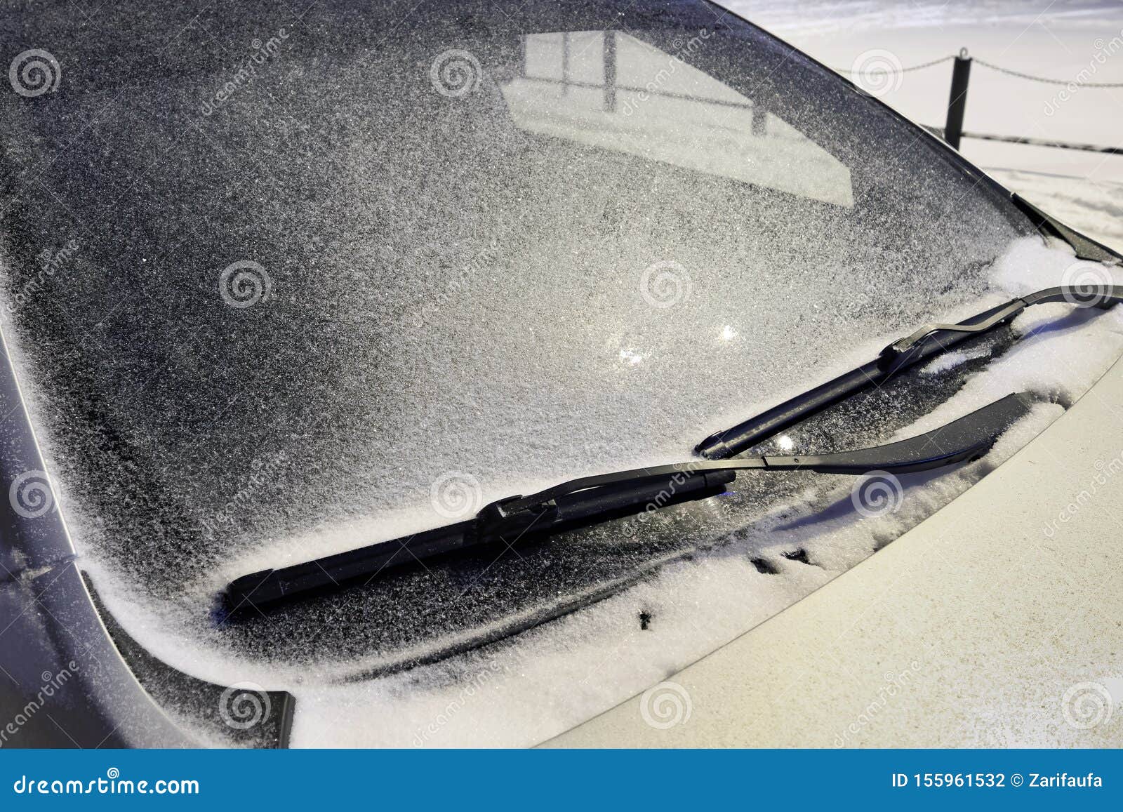 Car Windshield in the Snow in the Evening Under the Light of a Lantern