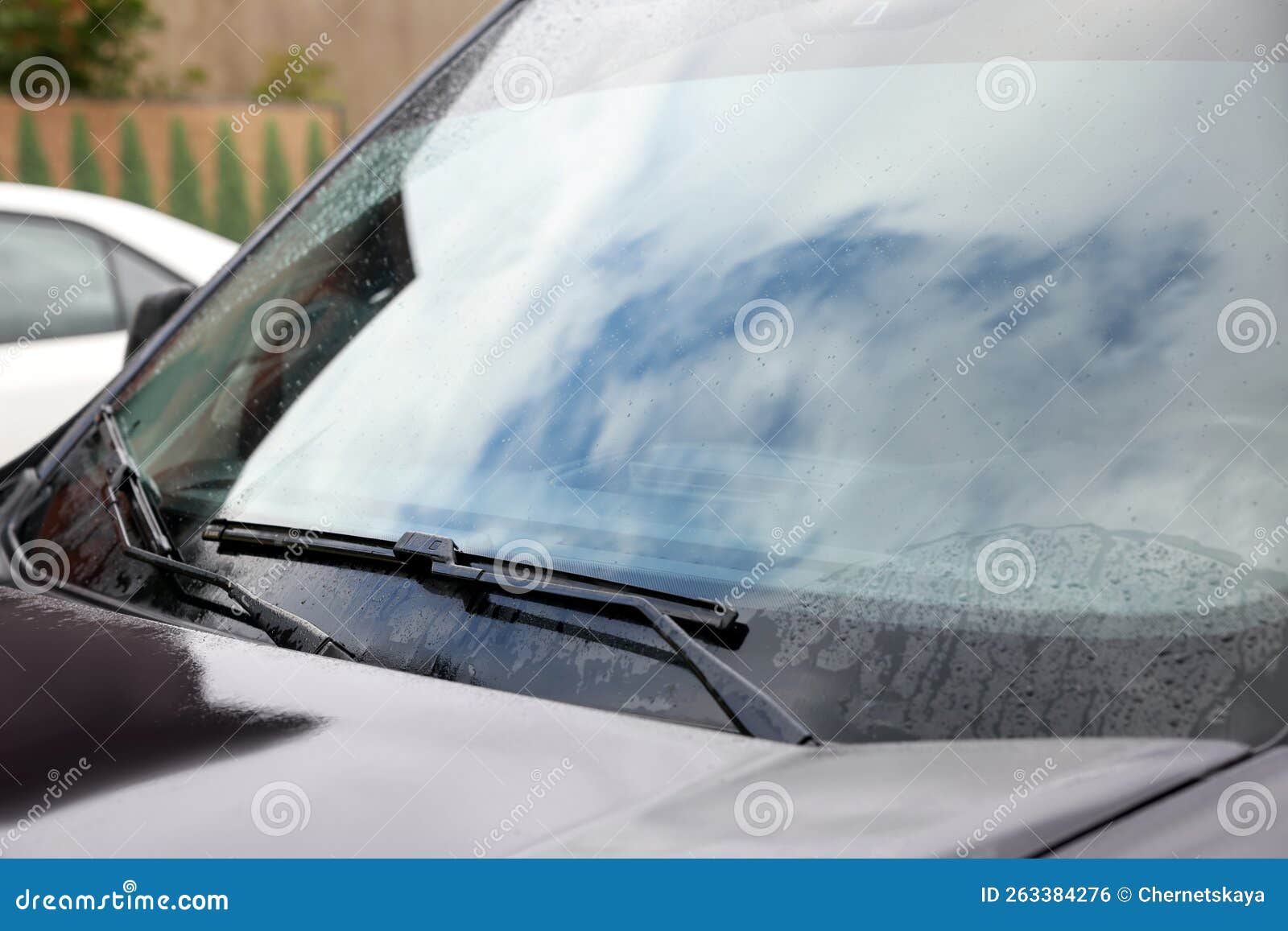 Car Wipers Cleaning Water Drops from Windshield Glass Outdoors, Closeup