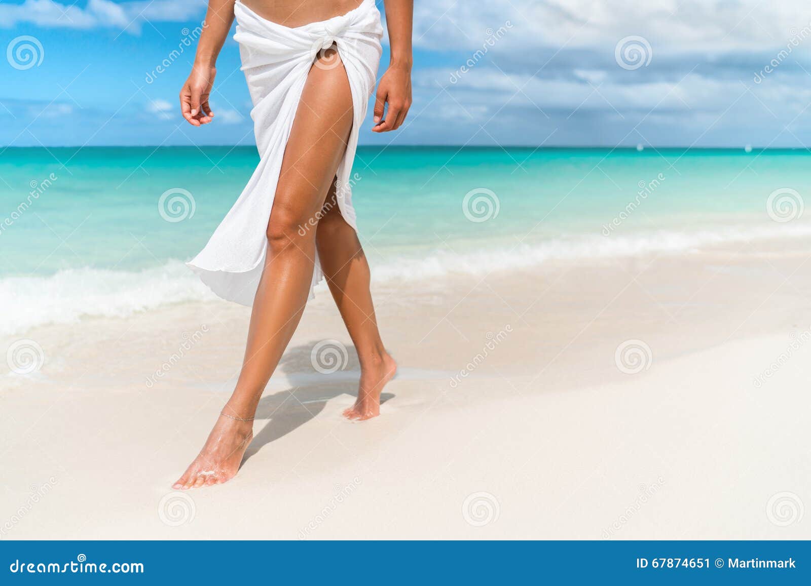 Caraïbische strandreis - de close-up die van vrouwenbenen op zand lopen. Caraïbische vakantiereis - de close-up die van het vrouwenbeen bij het witte zand ontspannen in pareostrandkleding van de stranddekmantel lopen Sexy magere en gelooide benen Sunmmervakantie, gewichtsverlies of epilationconcept