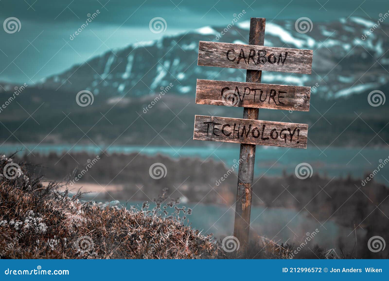 carbon capture technology text quote engraved on wooden signpost outdoors in landscape looking polluted