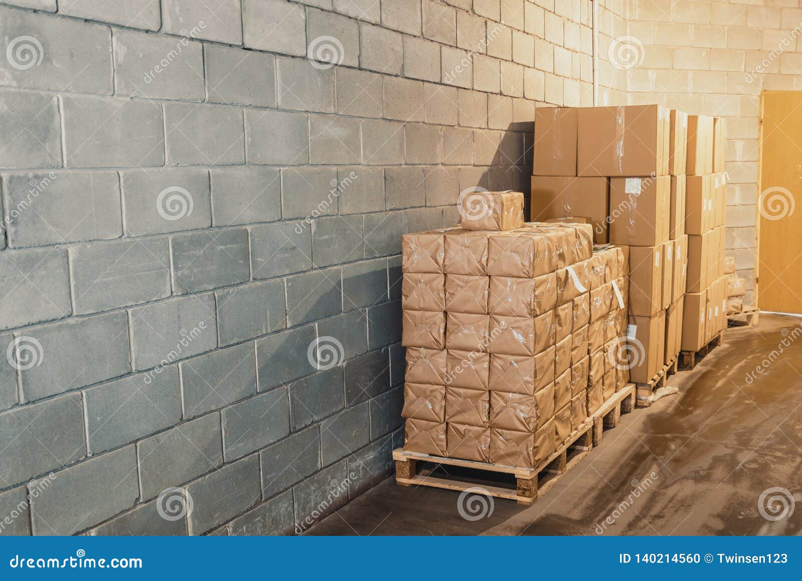 Cardboard Boxes on Pallets in a Warehouse Near the Concrete Wall Stock
