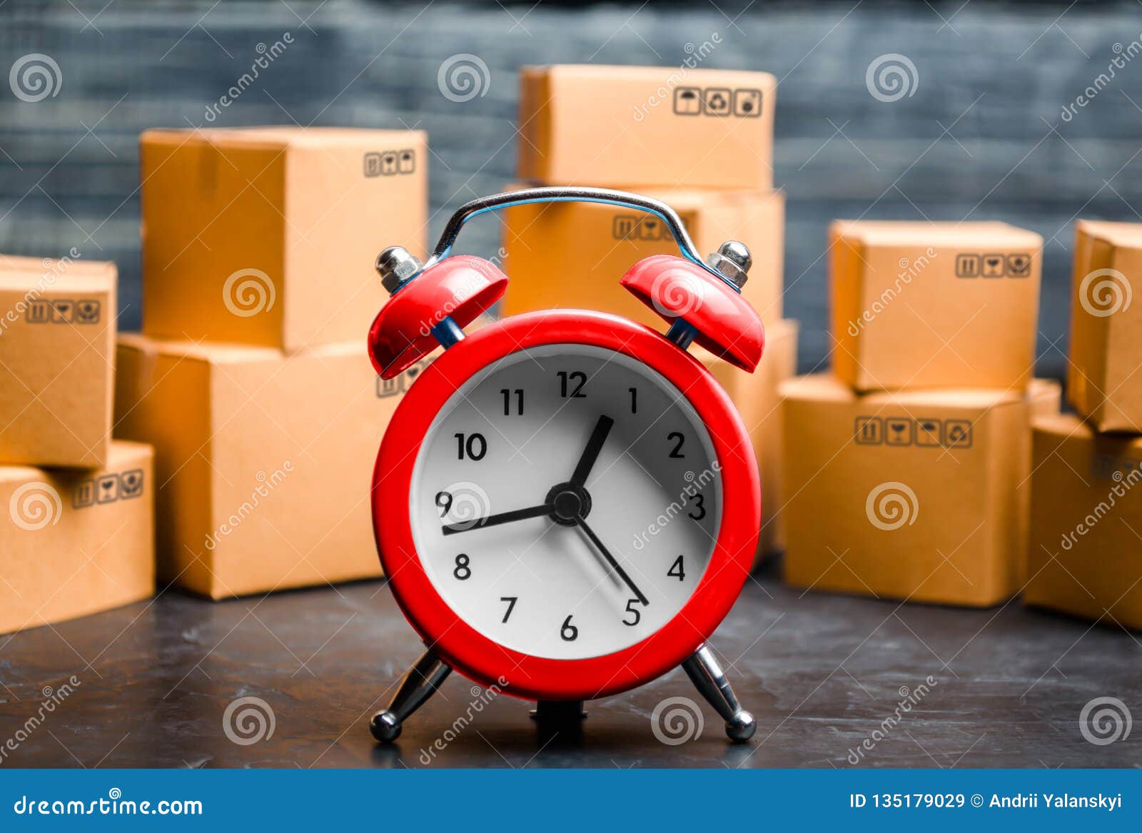 cardboard boxes and red alarm clock. time of delivery. limited supply, shortage of goods in stock, hype and consumer fever. time
