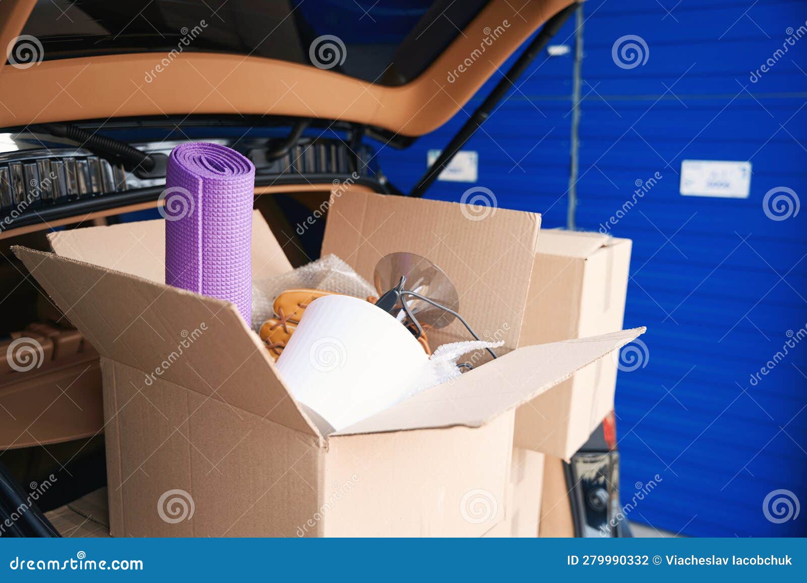 Cardboard Boxes with Things in the Trunk of Car into Warehouse Stock