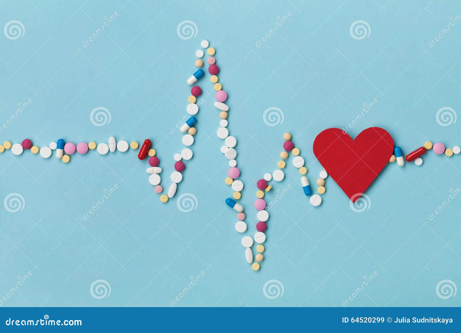 cardiogram is made of colorful drug pills and red paper heart, pharmaceutical and cardiology concept